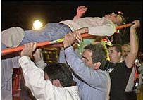 An injured man is carried from the scene of the Tel Aviv cafe blast